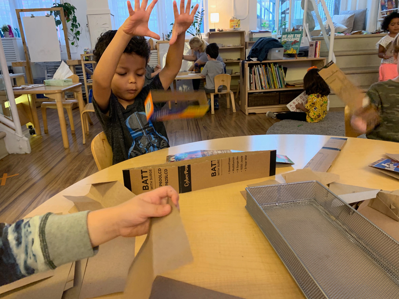 children playing with a cutout cardboard box