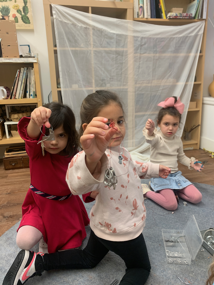 children holding up homemade jewelery