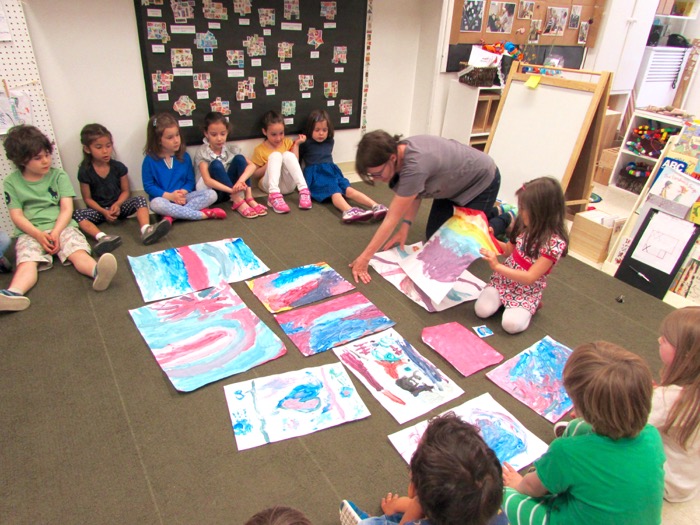 Teacher showing children's art to class