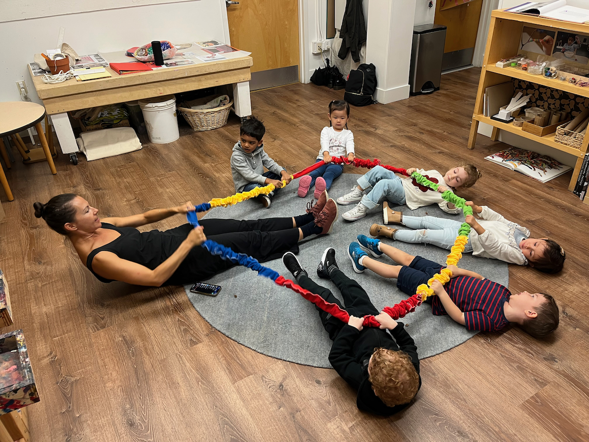 children practicing yoga in a circle on the ground