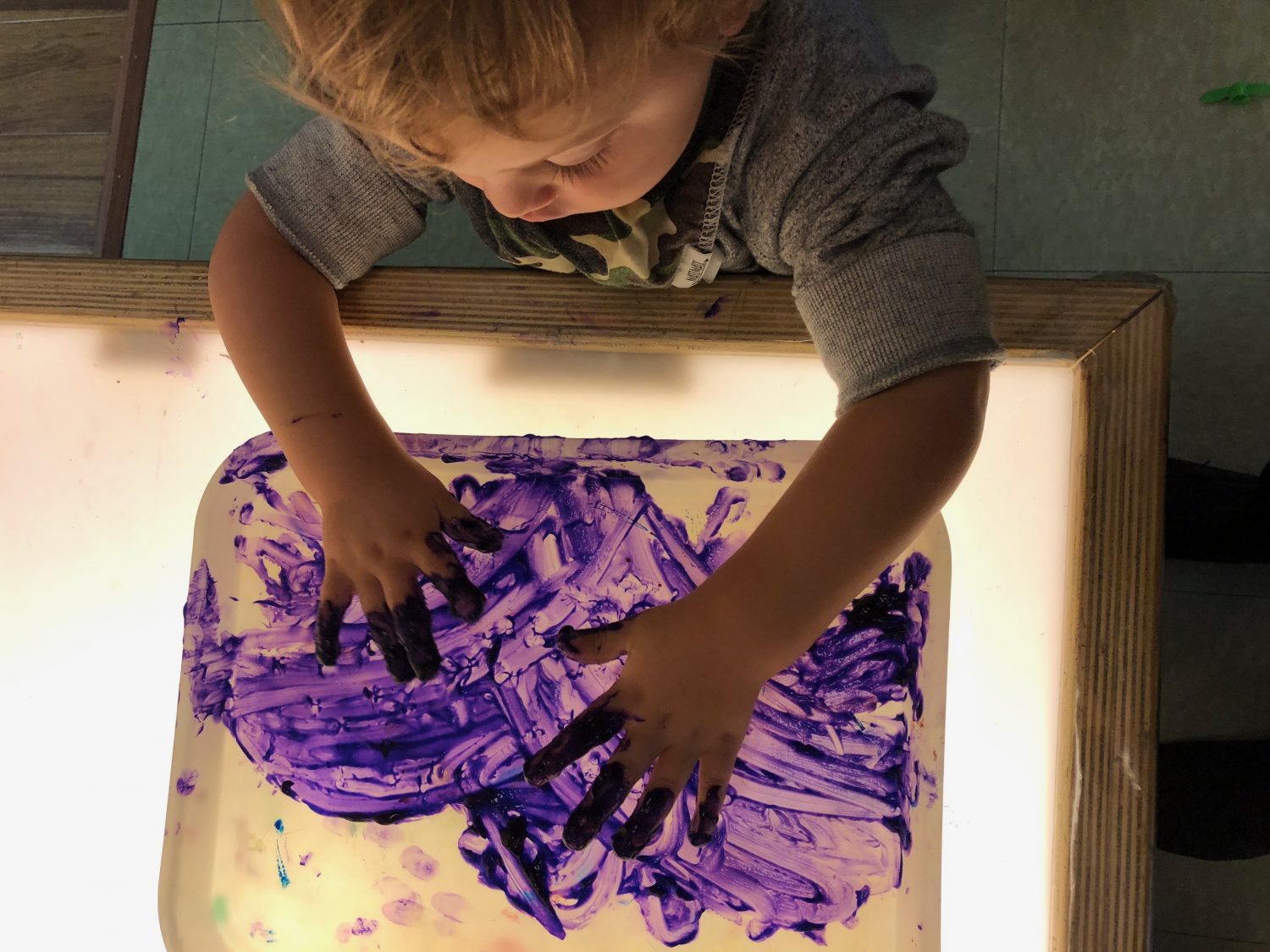 Child painting with hands