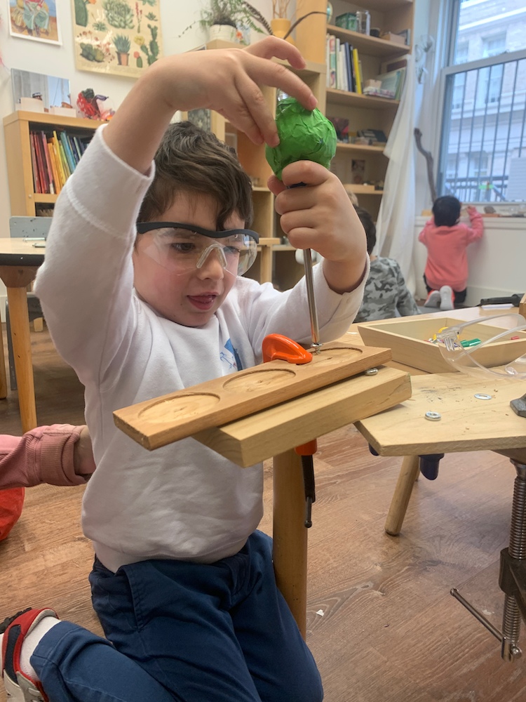 child using a screwdriver and on wood
