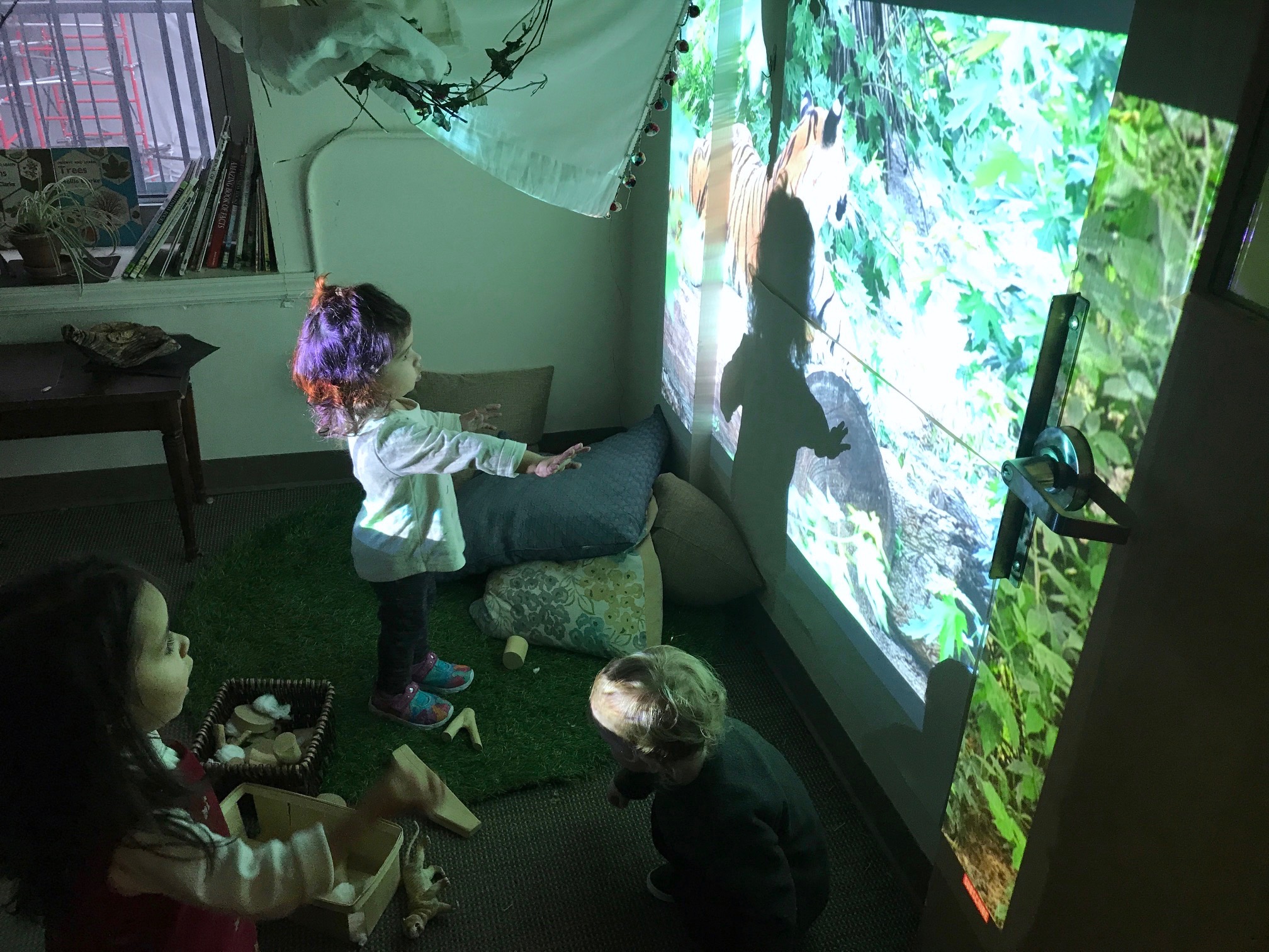 a child playing with a projector displaying a nature scene