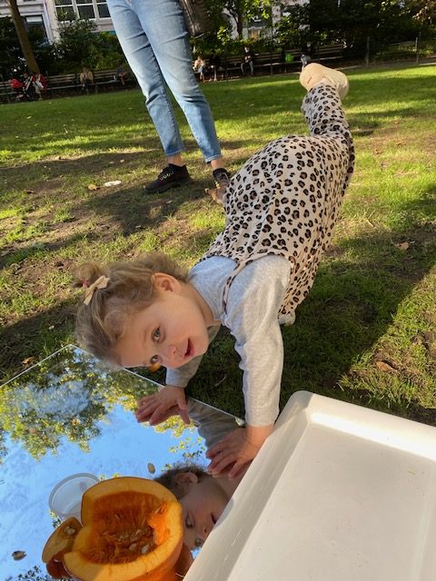 a child dancing on a mirror outside